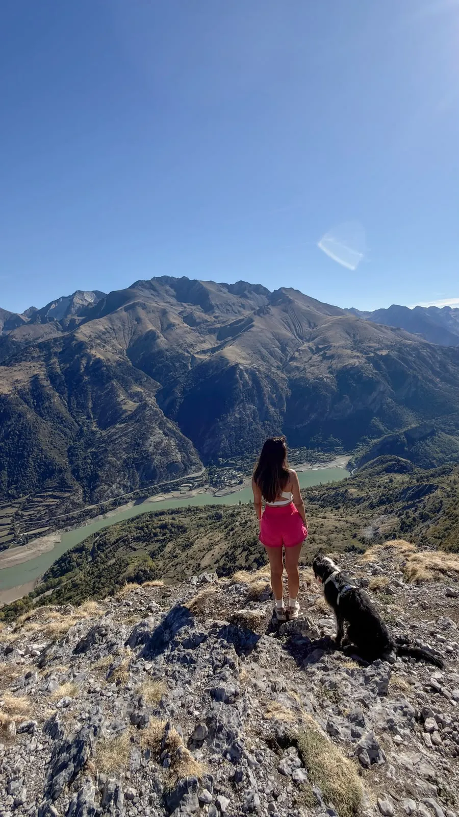 Kelly y Goofy en lo alto de una montaña del Pirineo, mirando al valle y a un embalse